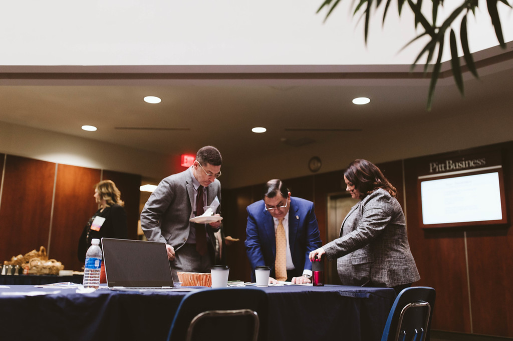 Dean Assad and two alumni reviewing a document at an event